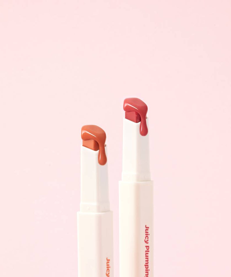 TOUCH IN SOL Vegan Again Juicy Plumping Lipstick de TOUCH IN SOL, tubes lèvres rouges sur fond rose pastel.