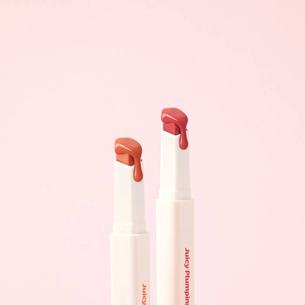 TOUCH IN SOL Vegan Again Juicy Plumping Lipstick de TOUCH IN SOL, tubes lèvres rouges sur fond rose pastel.