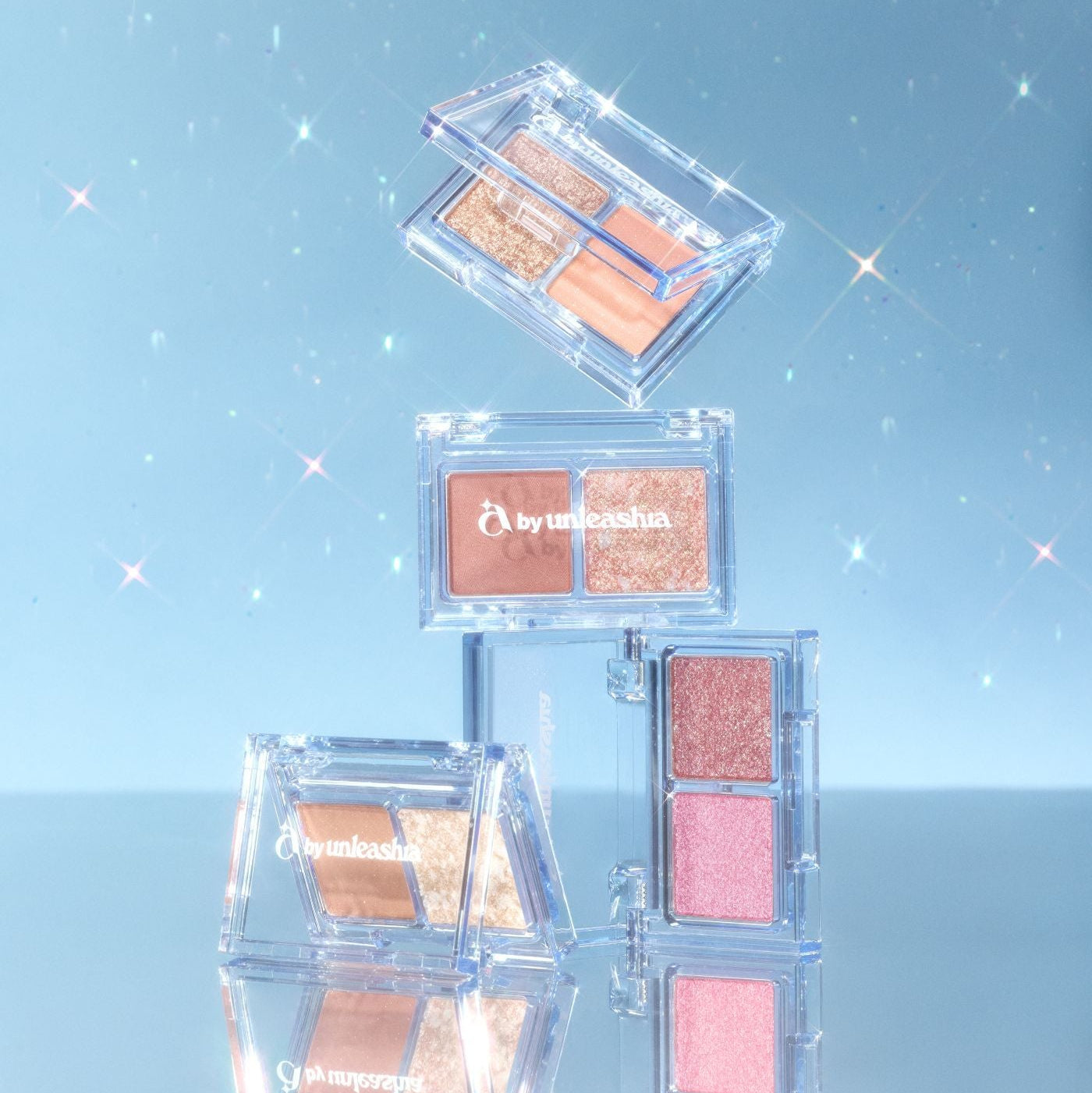 UNLEASHIA Cotton Candy Face Palette de la marque UNLEASHIA, maquillage en palette transparente sur fond bleu scintillant.