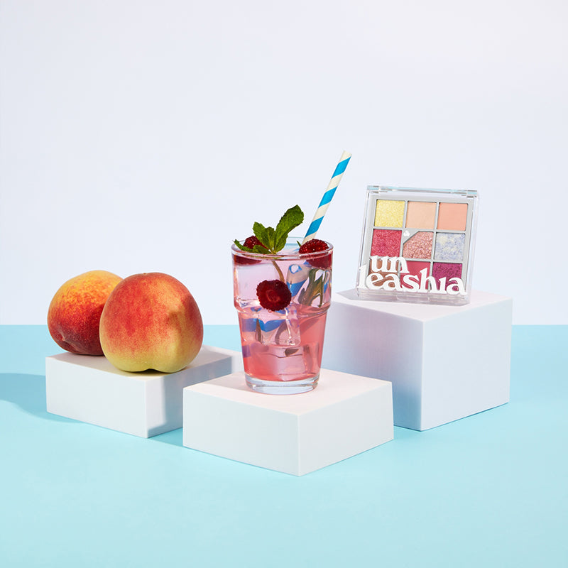 UNLEASHIA Glitterpedia Eye Palette de la marque UNLEASHIA, packaging maquillage sur cubes blancs, décor fruits et cocktail.