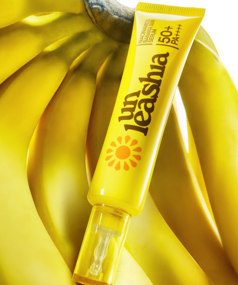 UNLEASHIA Niacinamide Banana Sun Serum 40ml, tube jaune sur tissu banane ensoleillé, marque UNLEASHIA, produit skincare