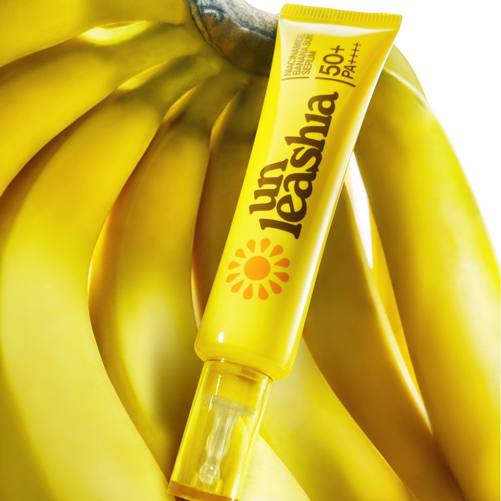 UNLEASHIA Niacinamide Banana Sun Serum 40ml, tube jaune sur tissu banane ensoleillé, marque UNLEASHIA, produit skincare