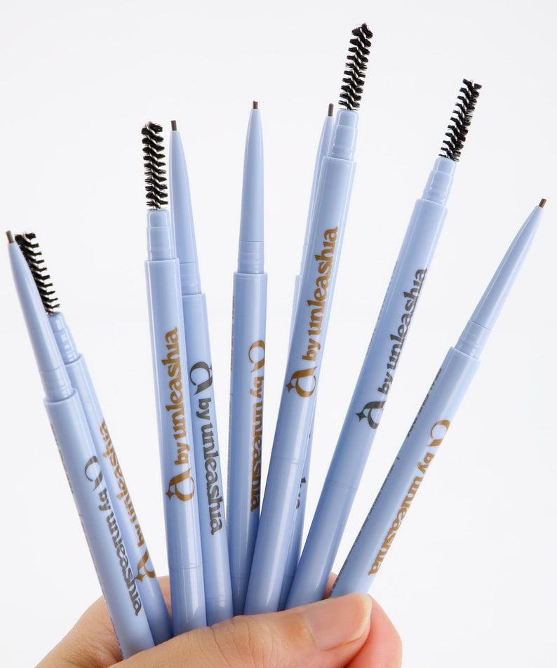 UNLEASHIA Real Fine 1mm Eyebrow Pencil, crayons sourcils UNLEASHIA, gros plan sur des stylos bleus, toile blanche.
