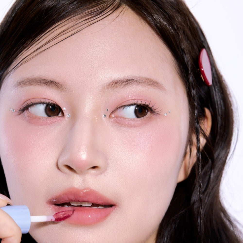 UNLEASHIA Tanghulu Glaze Tint sur lèvres, gros plan maquillage brillant de la marque UNLEASHIA sur fond clair.