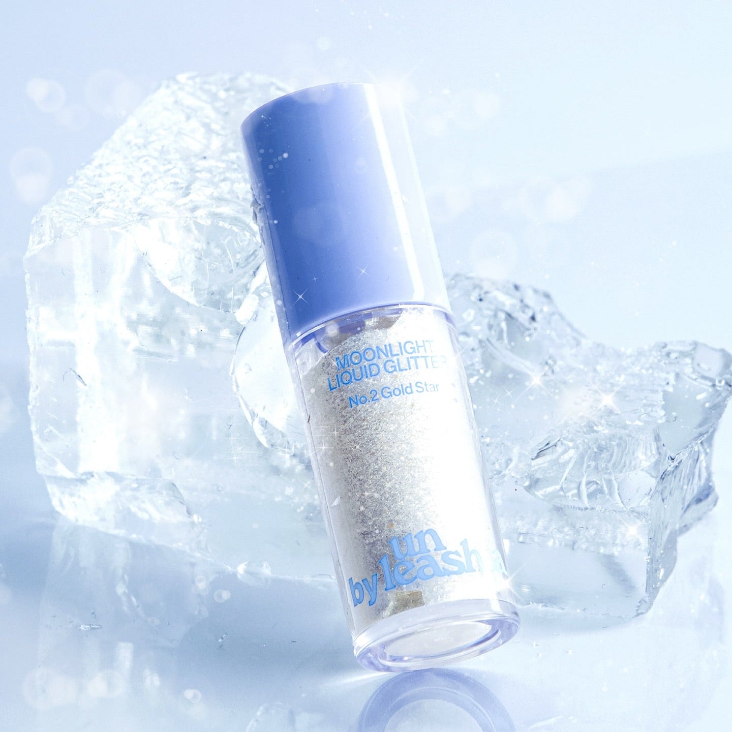 UNLEASHIA the Moonlight Liquid Glitter de la marque UNLEASHIA, flacon bleu scintillant sur glace, contexte lumineux