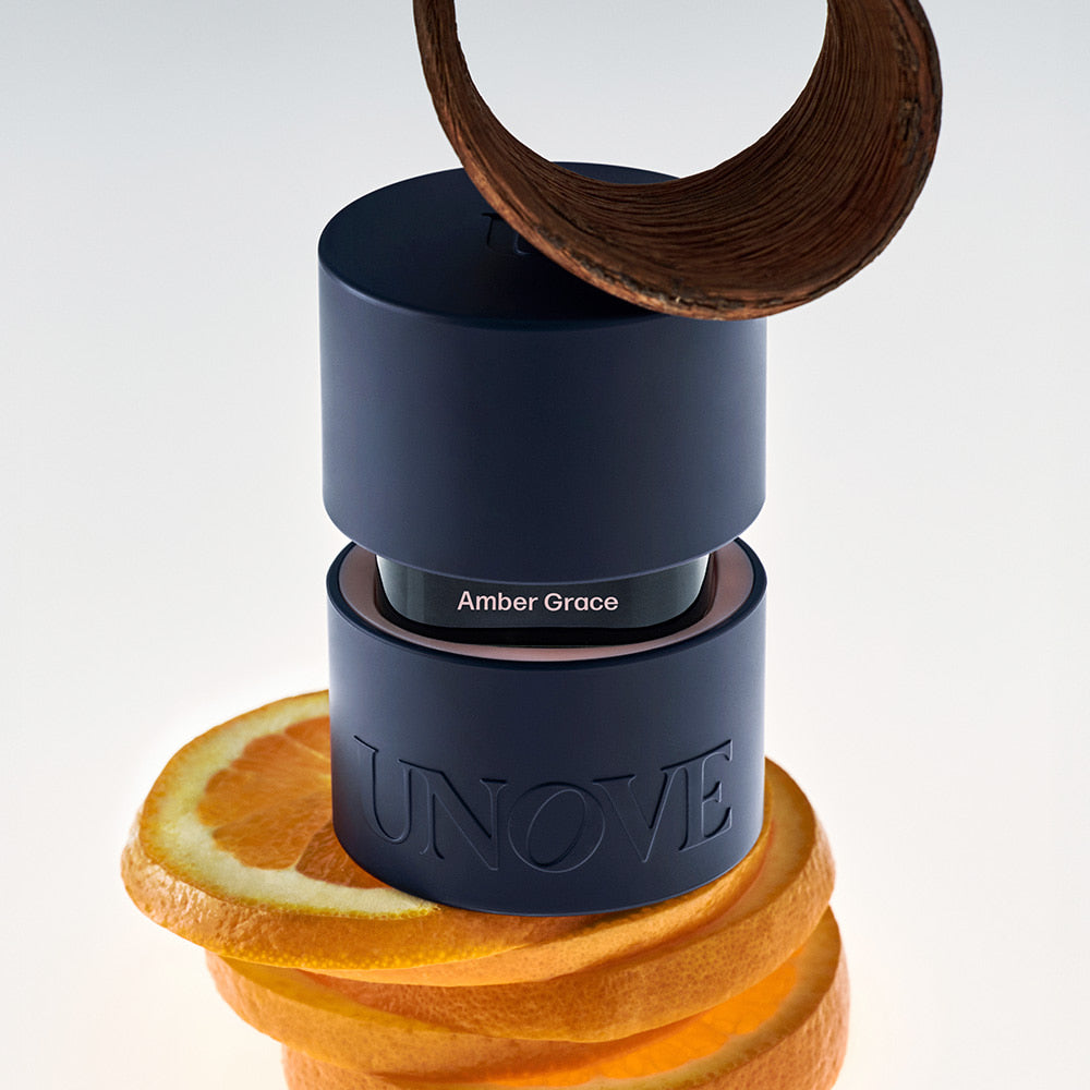 UNOVE Eau De Parfume de la marque UNOVE, flacon bleu sur fond blanc, entouré d’agrumes et de ruban bois.