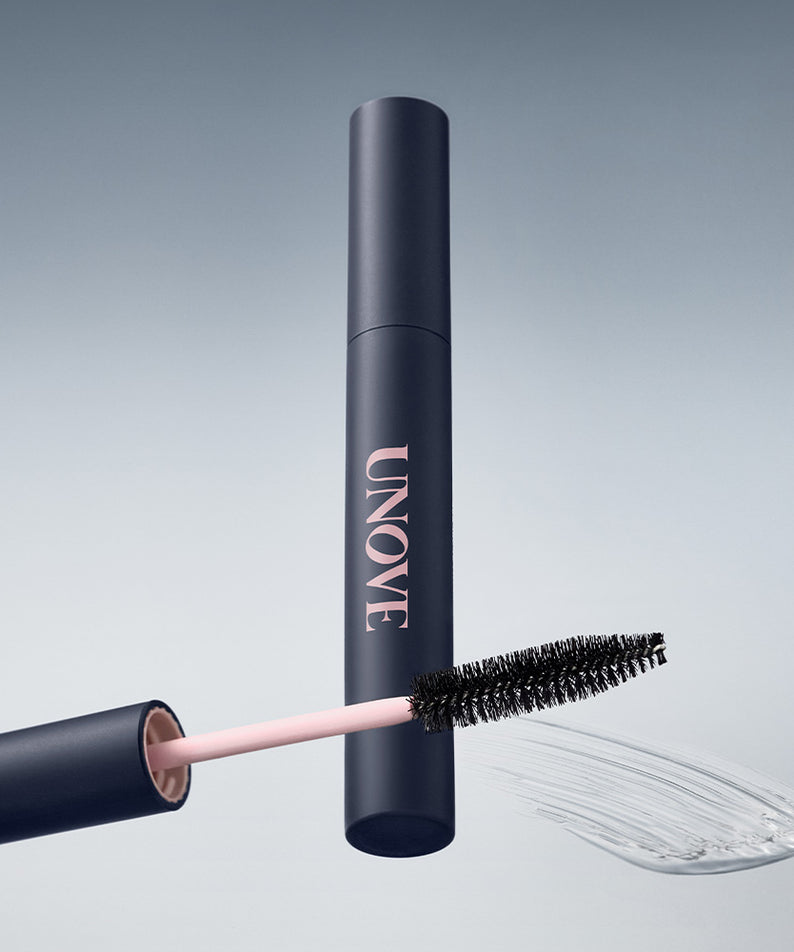 UNOVE Frizz Calming Slick Hair Finishing Stick 10ml de la marque UNOVE, stick coiffant noir et rose, fond clair.