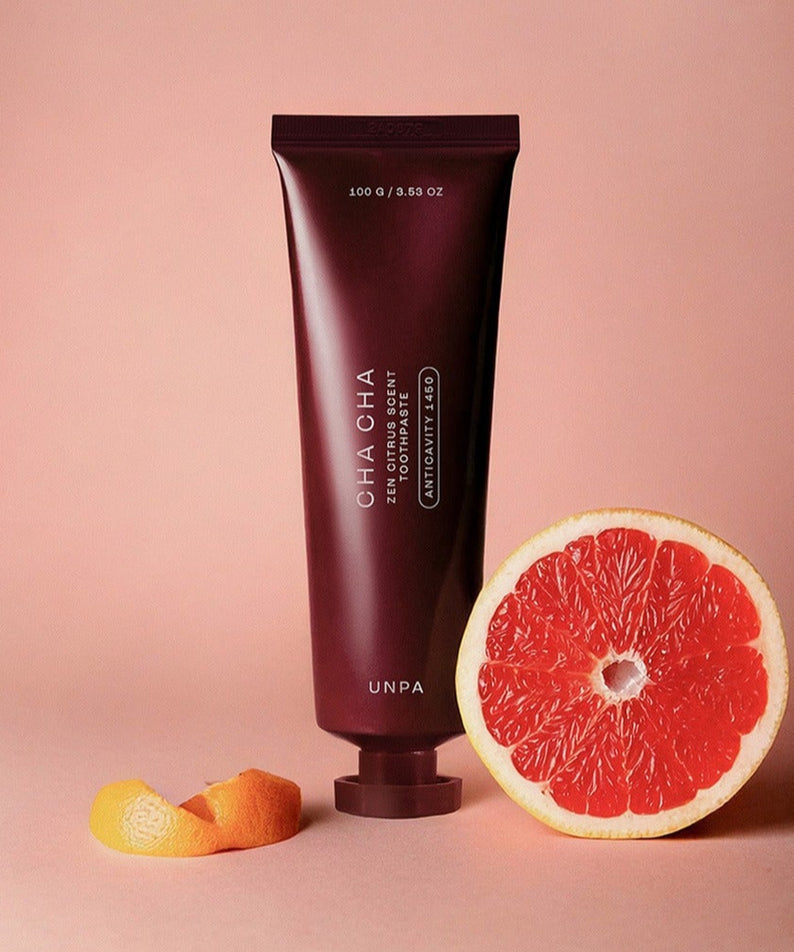 UNPA Cha Cha Zen Grapfruit Scent 1450 High Fluoride Toothpaste 100g UNPA, tube sur fond rose avec pamplemousse