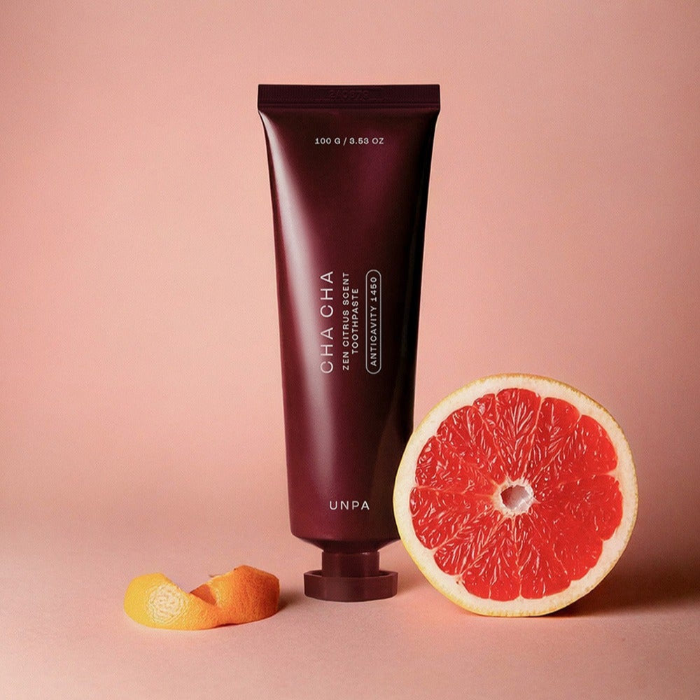UNPA Cha Cha Zen Grapfruit Scent 1450 High Fluoride Toothpaste 100g UNPA, tube sur fond rose avec pamplemousse