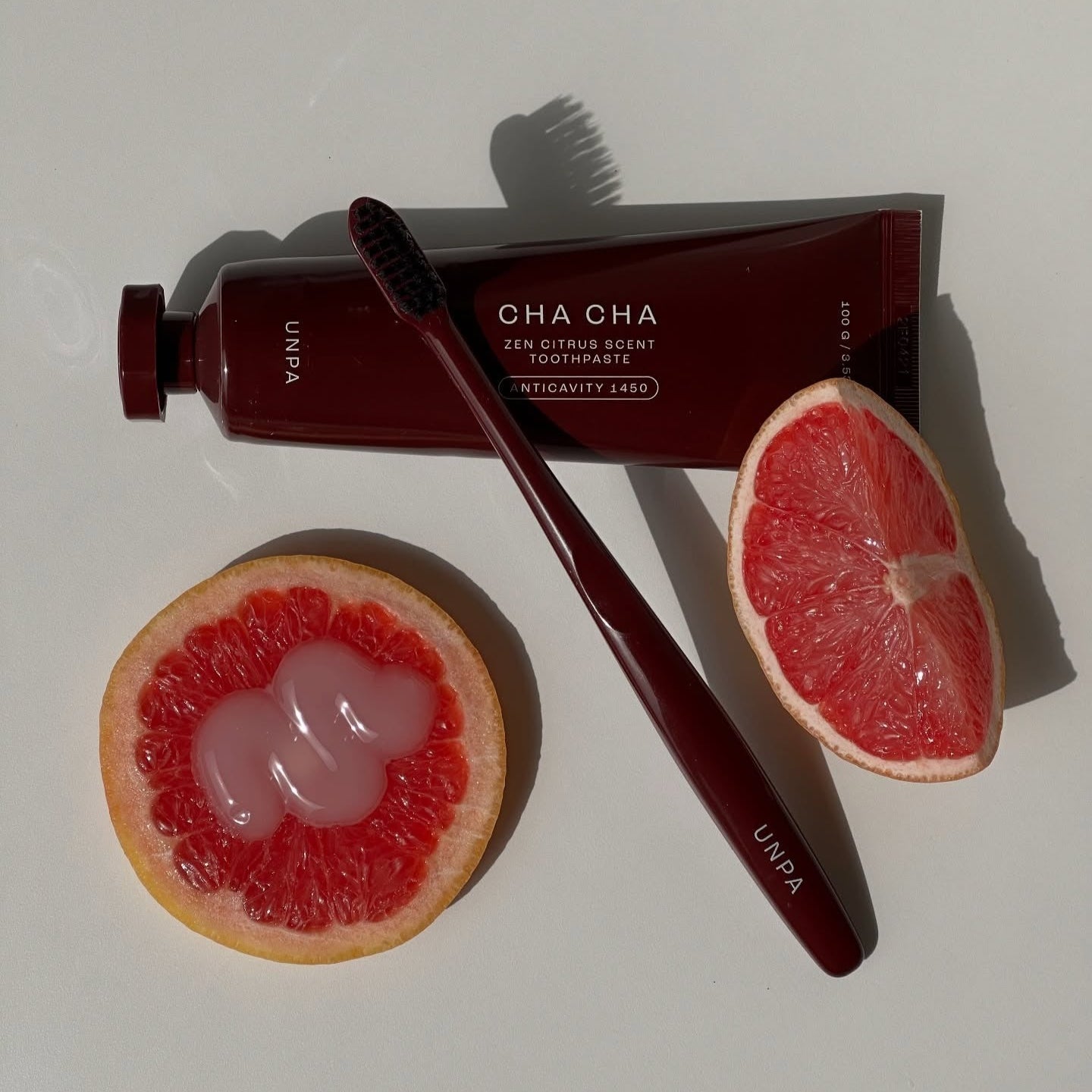 UNPA Cha Cha Zen Grapfruit Scent 1450 High Fluoride Toothpaste 100g de UNPA, pâte et brosse sur pamplemousse.