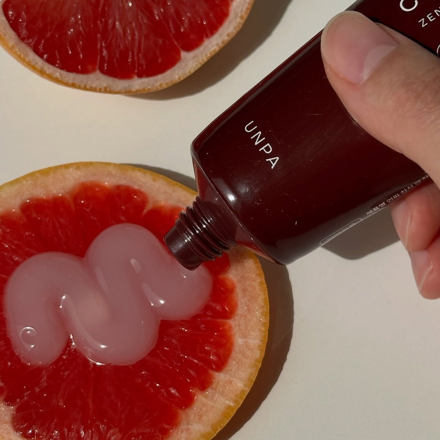 UNPA Cha Cha Zen Grapfruit Scent 1450 High Fluoride Toothpaste 100g de la marque UNPA, posée sur pamplemousse en gros plan.