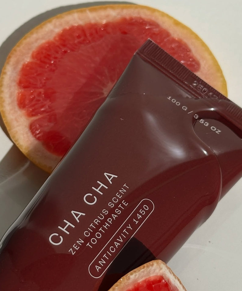 UNPA Cha Cha Zen Grapfruit Scent 1450 High Fluoride Toothpaste 100g de la marque UNPA, boîte sur tranche de pamplemousse