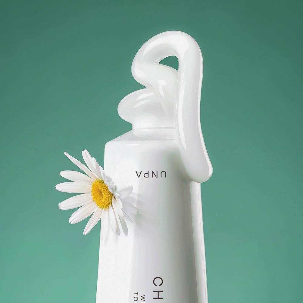 UNPA Chacha French Chamomile Vegan Whitening Toothpaste 90g de la marque UNPA, flacon blanc avec marguerite, fond vert.