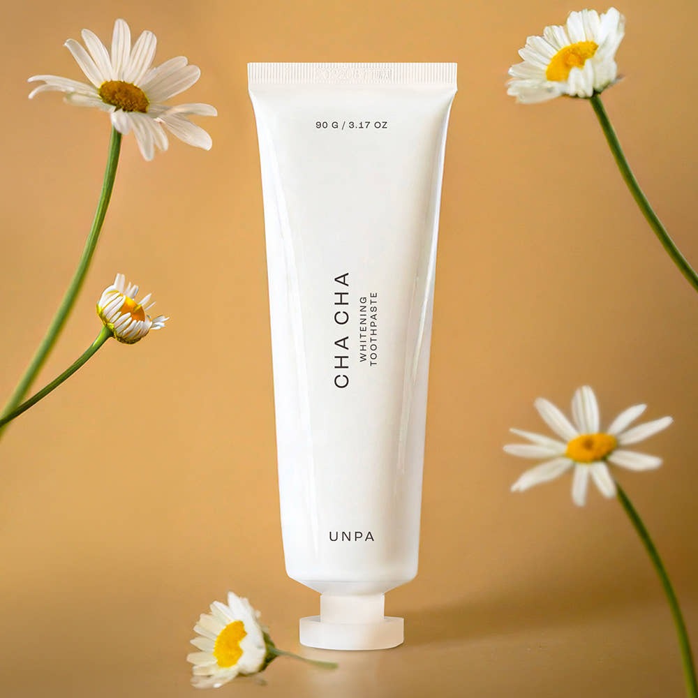 UNPA Chacha French Chamomile Vegan Whitening Toothpaste 90g, tube blanc UNPA, fleurs de camomille sur fond beige.