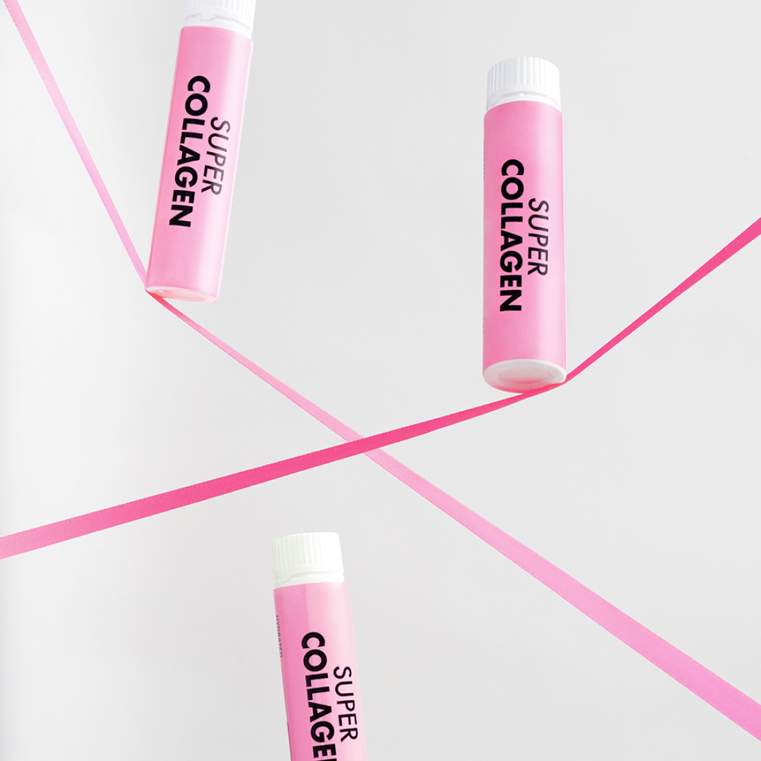 VITAL BEAUTIE Super Collagen 28 Tablets, tubes roses sur fond blanc avec lignes fuchsia, contexte produit de marque