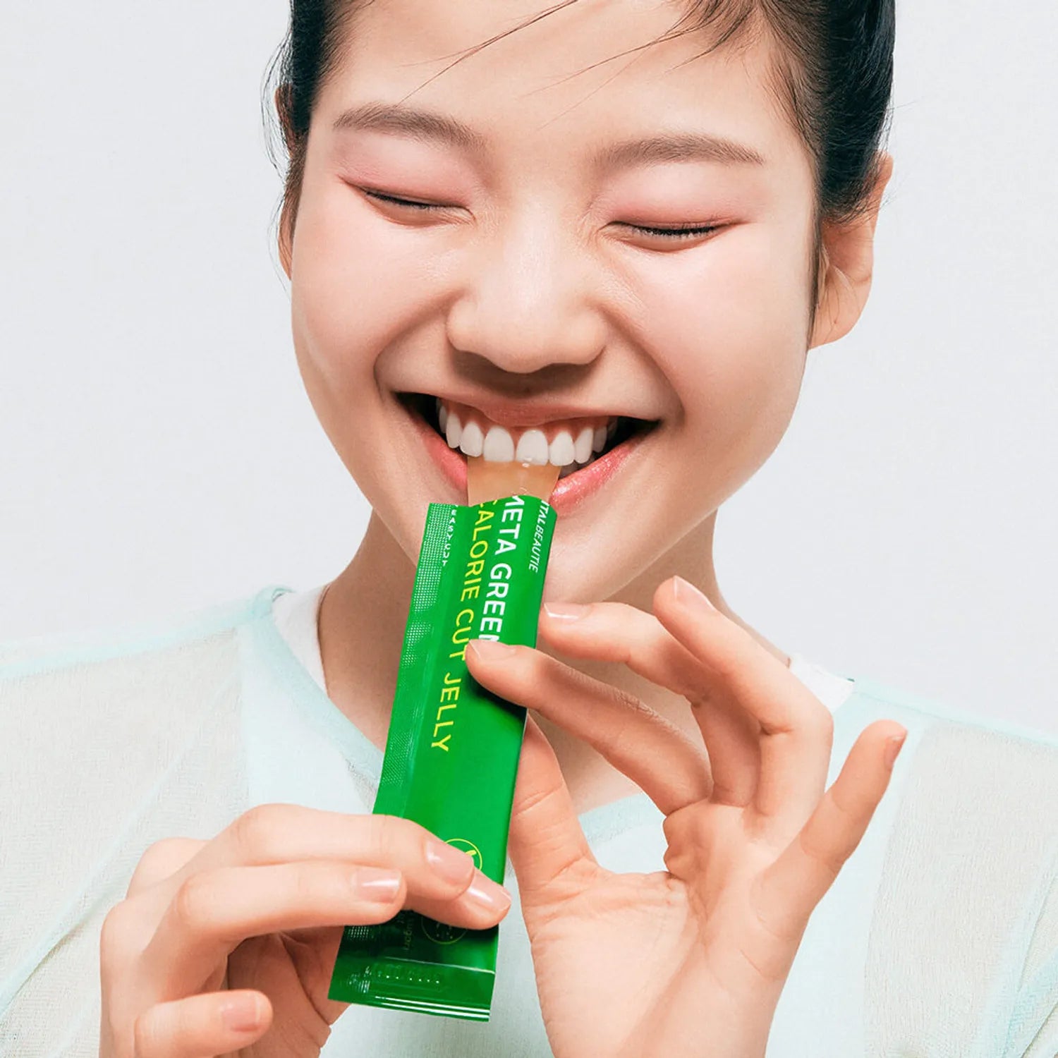 VITALBEAUTIE Meta Green Calorie Cut Jelly 10 Packets : femme souriante tenant un sachet vert, produit en gros plan sur fond clair