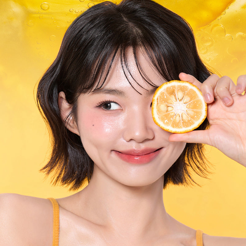 VT COSMETIC Vitamin C Astaxanthin Serum 30ml : flacon VT COSMETIC, femme tenant une tranche d’orange sur fond jaune