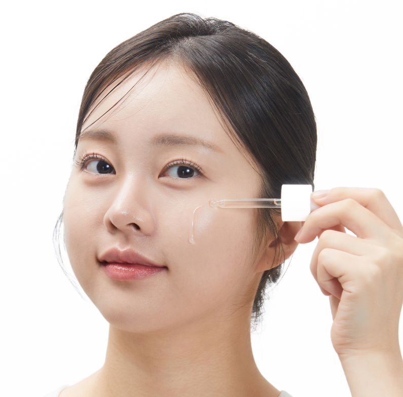 VT COSMETICS  G2 Glutathione Brightening Ampoule 30ml, sérum éclaircissant; la femme applique le produit sur le visage.
