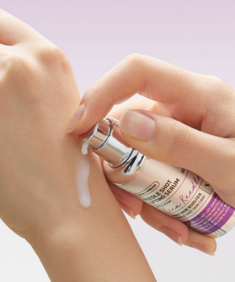 VT COSMETICS  Riddle Shot Lifting Serum 30ml : application du sérum sur une peau, mains et flacon de la marque, fond clair.