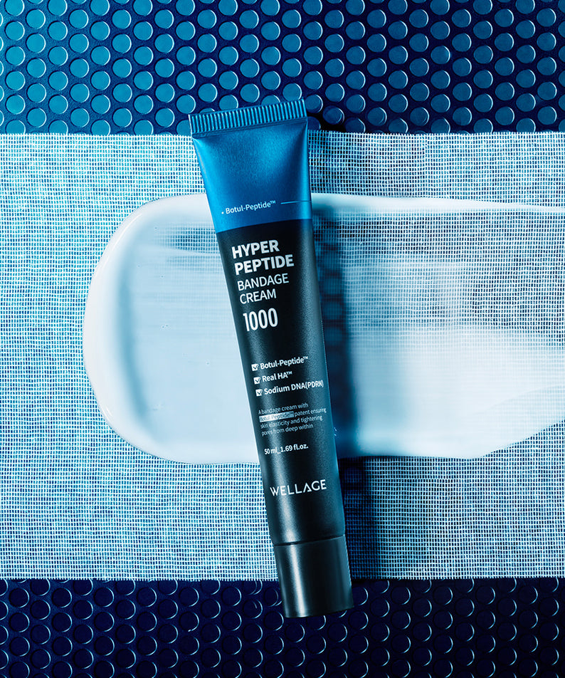 WELLAGE Hyper Peptide Bandage Cream 50ml sur fond bleu avec motif texture, marque visible en contexte visuel soins