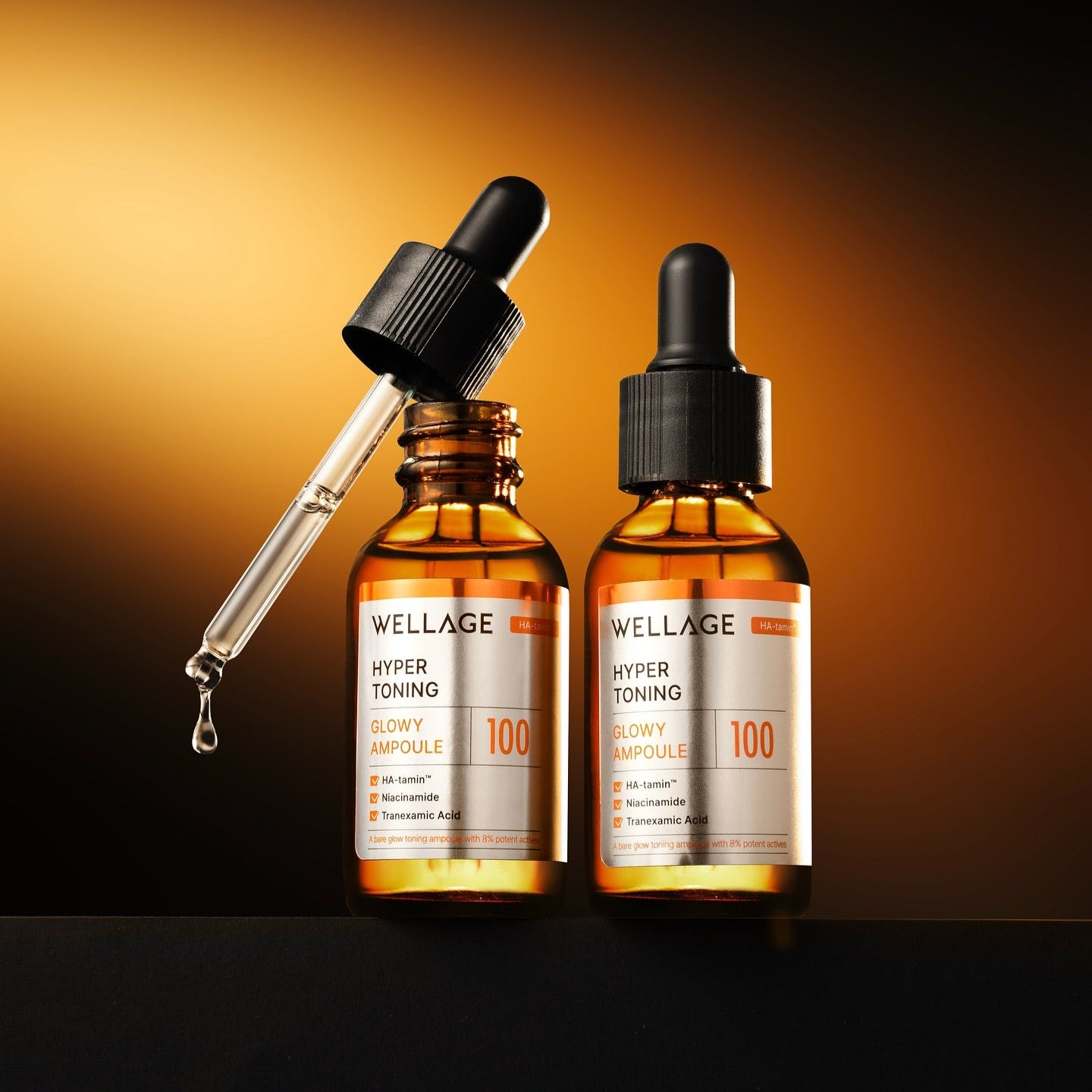 WELLAGE Hyper Toning Glow Ampoule 30ml, marque WELLAGE, sérum en flacons avec goutteur sur fond orange en studio.