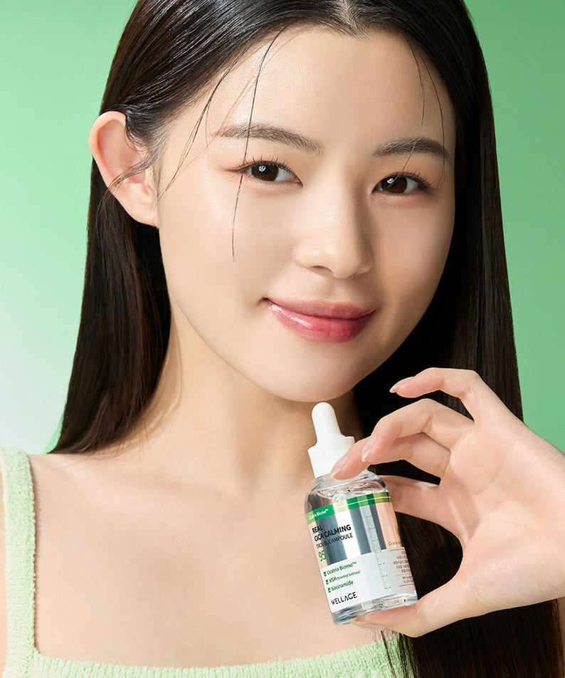 Portrait beauté sur fond vert : WELLAGE Real Cica Calming 95 Trouble Ampoule 50ml tenu par une femme, ambiance apaisante.