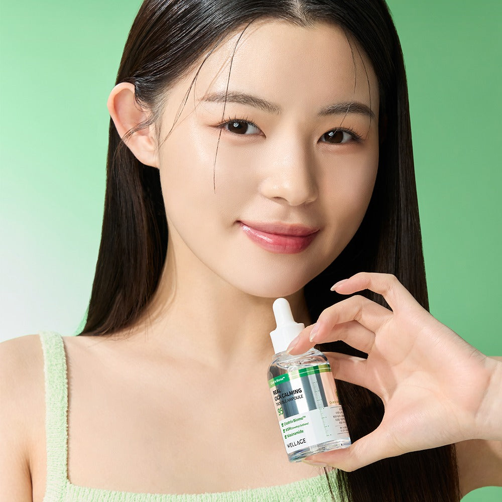 Portrait beauté sur fond vert : WELLAGE Real Cica Calming 95 Trouble Ampoule 50ml tenu par une femme, ambiance apaisante.