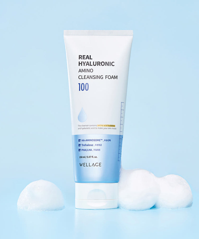 WELLAGE  Real Hyaluronic Amino Cleansing Foam 150ml, tube de nettoyant sur fond bleu avec bulles blanches.