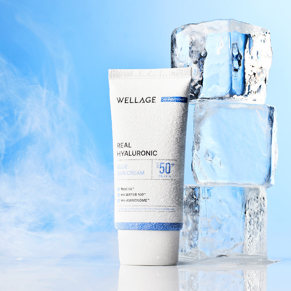 WELLAGE  Real Hyaluronic Blue Sunscreen 50ml, crème solaire hydratante sur fond bleu, bouteille et tube en contexte fraîcheur