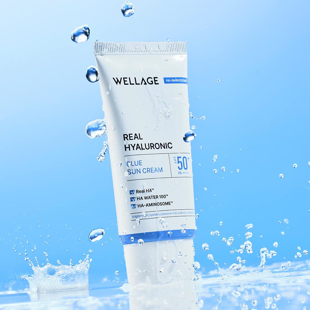 WELLAGE  Real Hyaluronic Blue Sunscreen 50ml : tube cosmétique bleu et gouttes d’eau sur fond clair, marque WELLAGE
