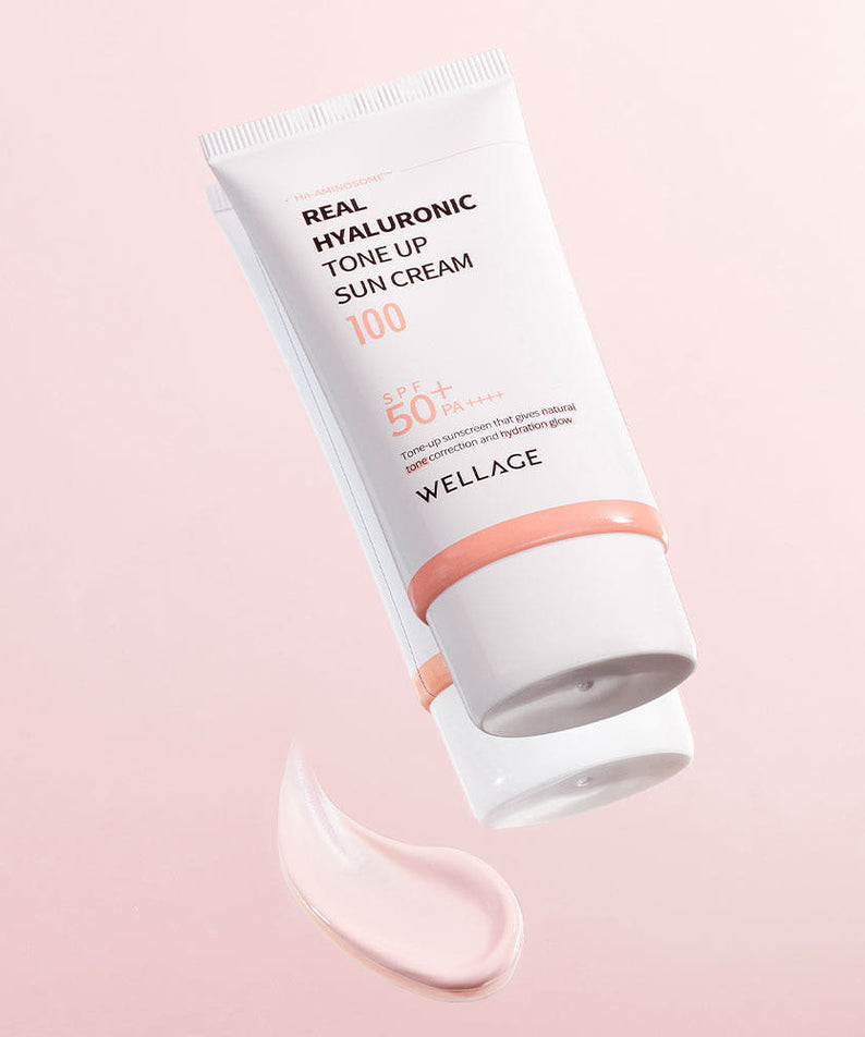 WELLAGE Real Hyaluronic Tone-Up Sunscreen 50ml sur fond rose, tube et texture crème hydratante, marque WELLAGE visible.