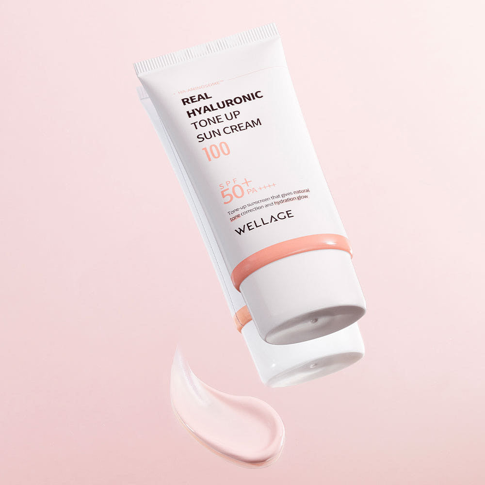 WELLAGE Real Hyaluronic Tone-Up Sunscreen 50ml sur fond rose, tube et texture crème hydratante, marque WELLAGE visible.