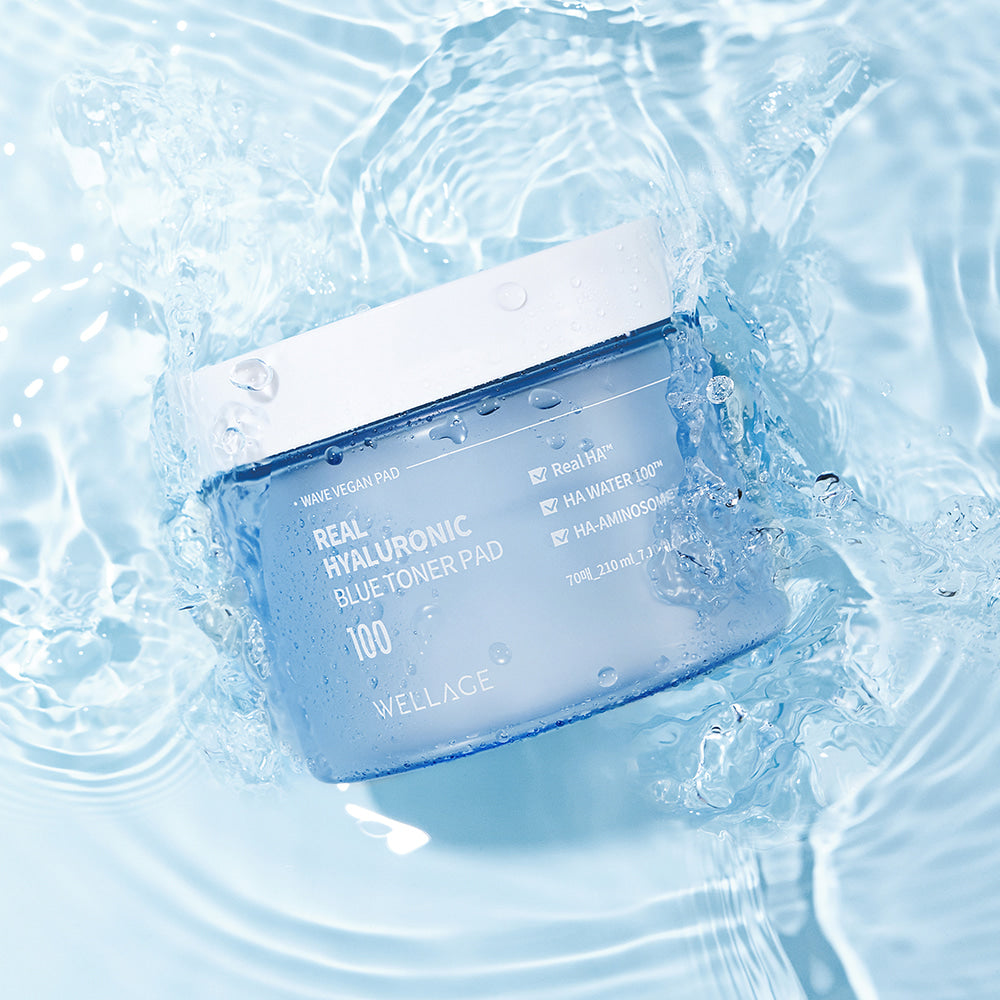 Décris l'image en français : WELLAGE Real hyaluronic Blue Toner Pads 70 Sheets, marques WELLAGE, dans un décor aquatique bleu.