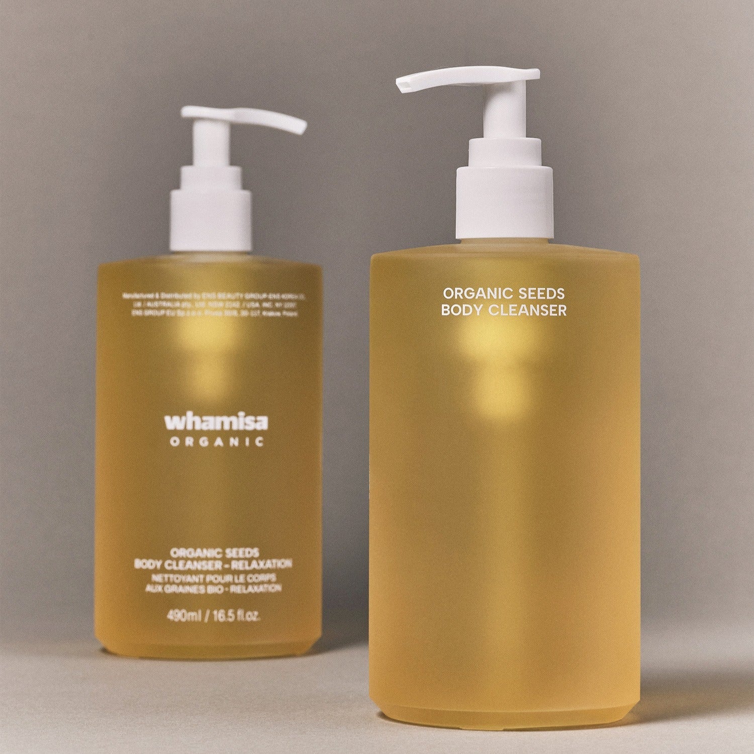 Décris l’image en français : WHAMISA Organic Seed Fermented Body Cleanser 490ml, deux flacons dorés avec pompes sur fond neutre.