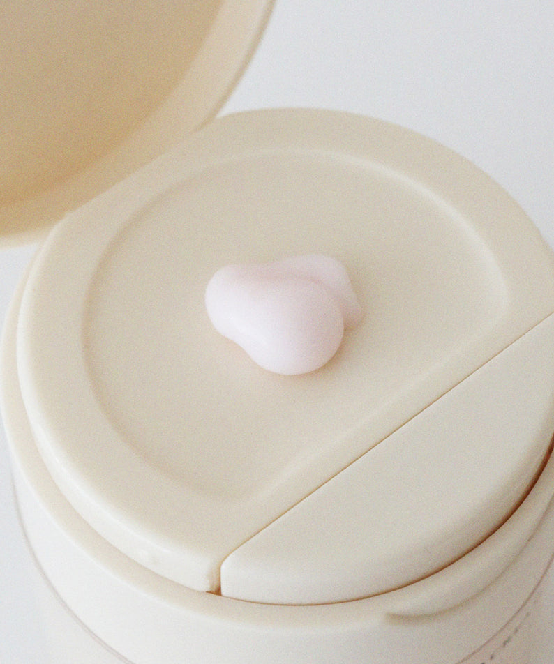 Crème XOUL Layered Cream 50g sur un couvercle beige, texture légère et rose, soin hydratant