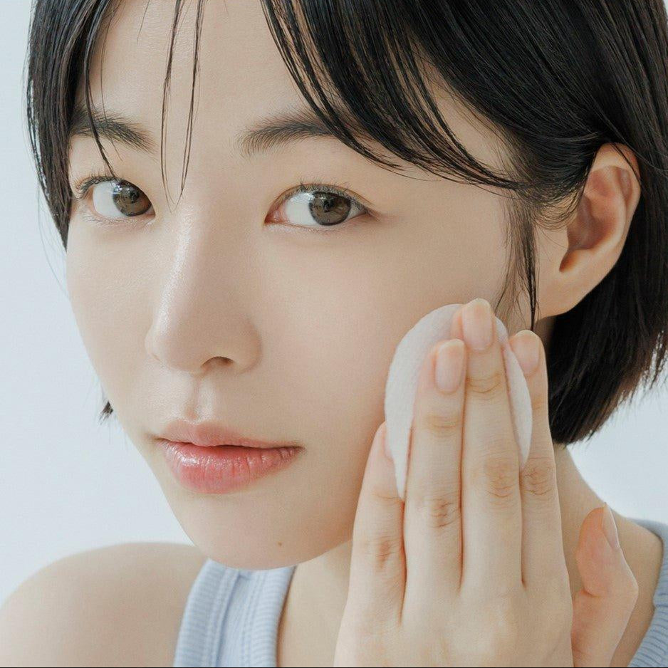 ABIB Sedum Hyaluron Pad Hydrating Touch 75p 165ml : jeune femme applique un pad hydratant sur le visage, gros plan.