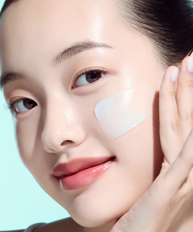 Je ne sais pas qui figure sur cette image mais une femme applique une crème sur sa joue.