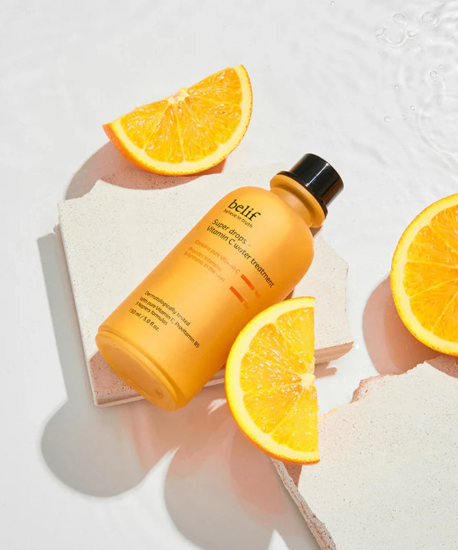 BELIF Super Drops-Vitamin C Water Treatment 150ml de Belif sur fond blanc, citrons et éclaboussures d’eau, bain skincare