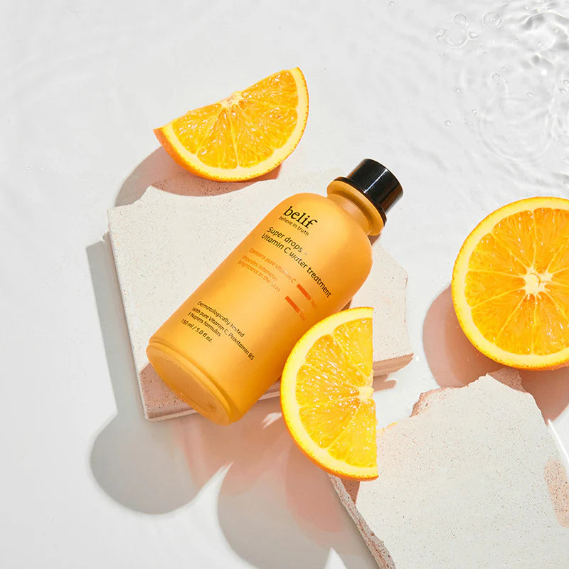 BELIF Super Drops-Vitamin C Water Treatment 150ml de Belif sur fond blanc, citrons et éclaboussures d’eau, bain skincare