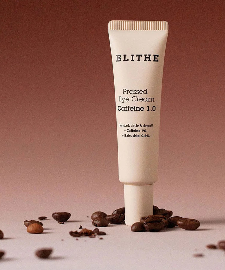 BLITHE Pressed Eye Cream 20ml, tube crème sous lumière douce sur grains de café, fond beige.