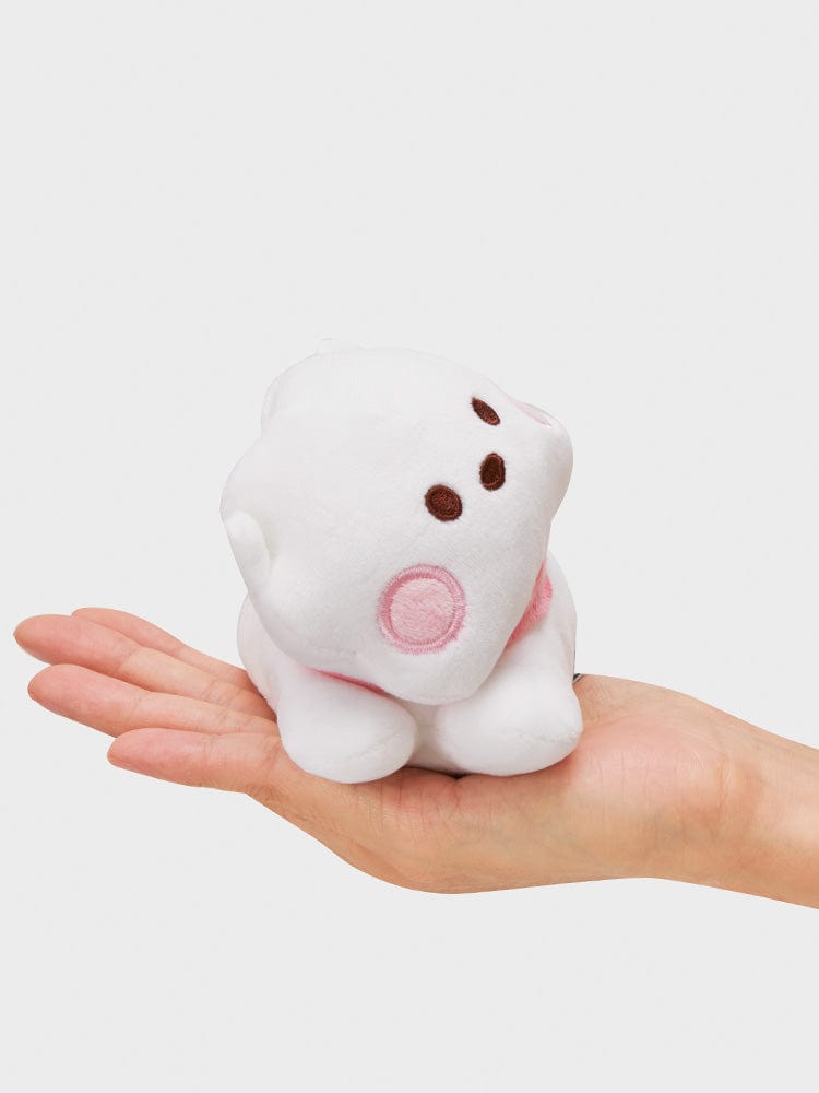 BT21 RJ minini LYING DOLL : peluche officielle RJ alpaga, tenue dans une main sur fond clair, ambiance mignonne.