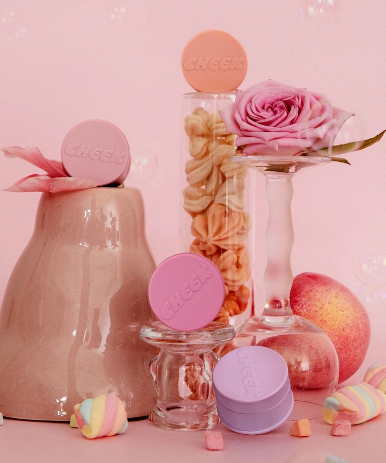 TONY MOLY Cheektone Jelly Blusher de la marque TONY MOLY, flacons roses et pêches sur fond pastel avec fleurs