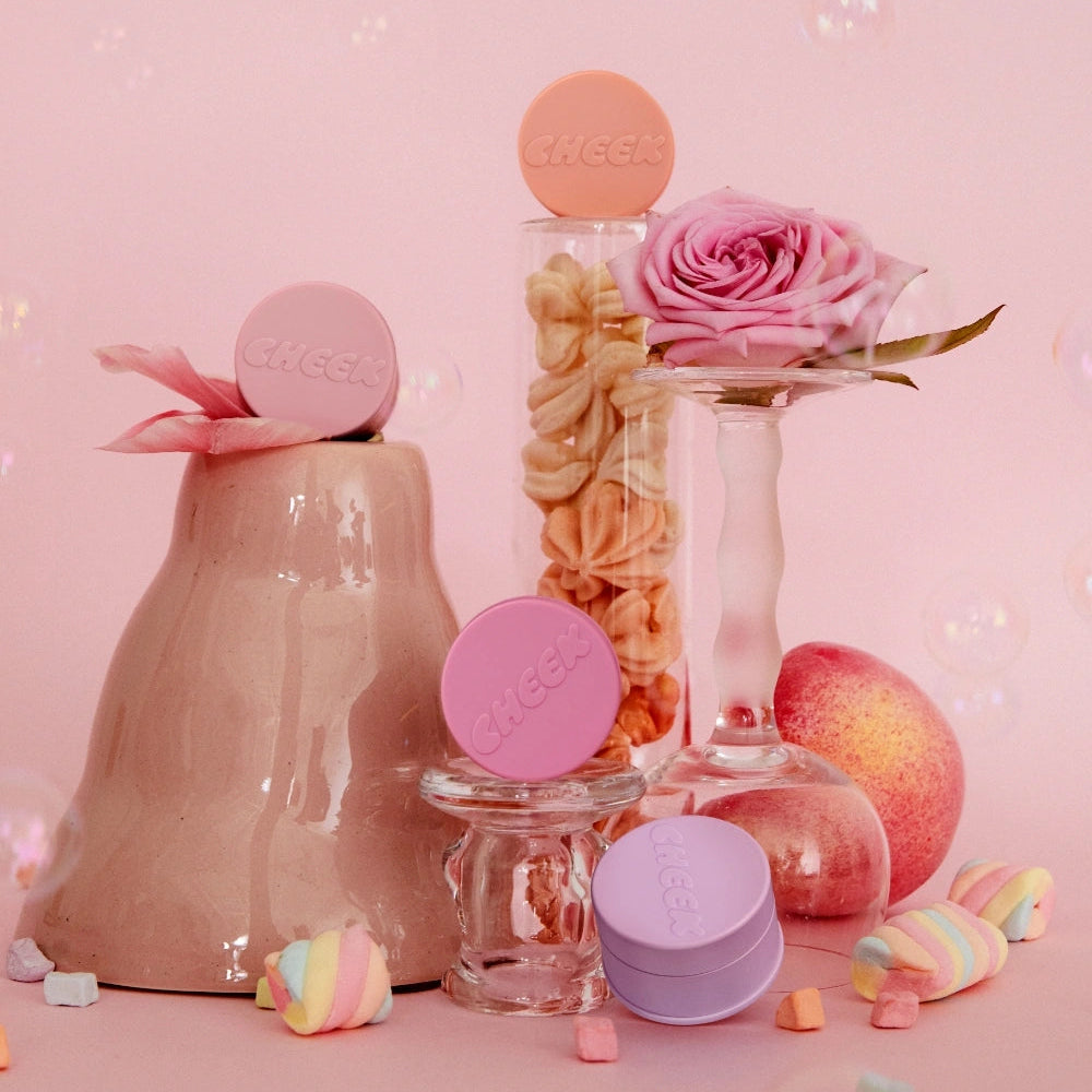 TONY MOLY Cheektone Jelly Blusher de la marque TONY MOLY, flacons roses et pêches sur fond pastel avec fleurs