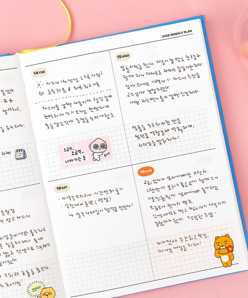 KAKAO FRIENDS Planner 2026 ouvert à la page hebdomadaire, avec illustrations colorées et textes en coréen, posé sur fond rose.