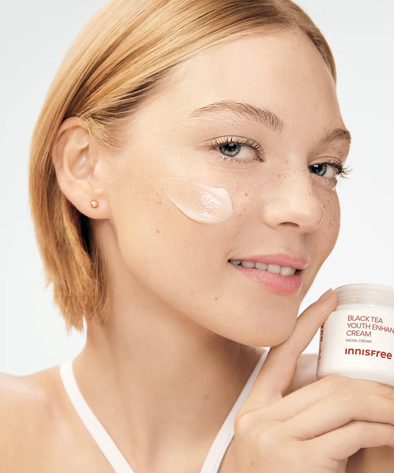 INNISFREE Black Tea Youth Enhancing Cream 50ml : pot en main, peau hydratée, fond clair, visage féminin, mise en scène beauté.