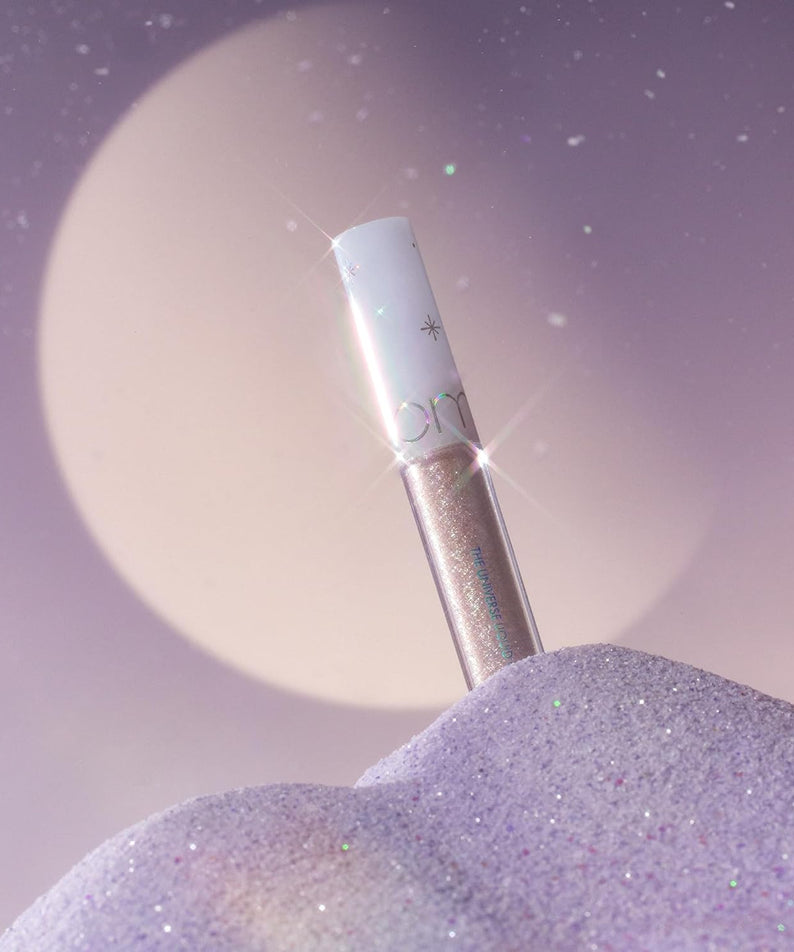 ROMAND The Universe Liquid Glitter, tube pailleté sur fond violet étoilé, éclat holographique de la marque ROMAND.
