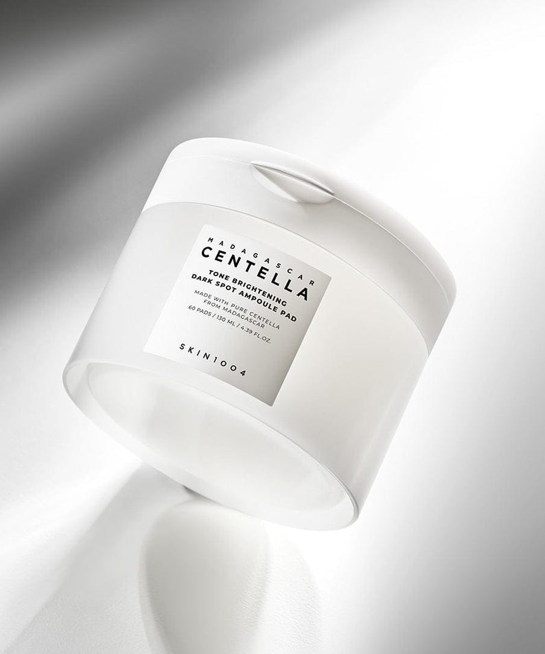 SKIN1004 Madagascar Centella Tone Brightening Dark Spot Ampoule Pads (60 sheets) sur fond blanc lumineux, pot incliné