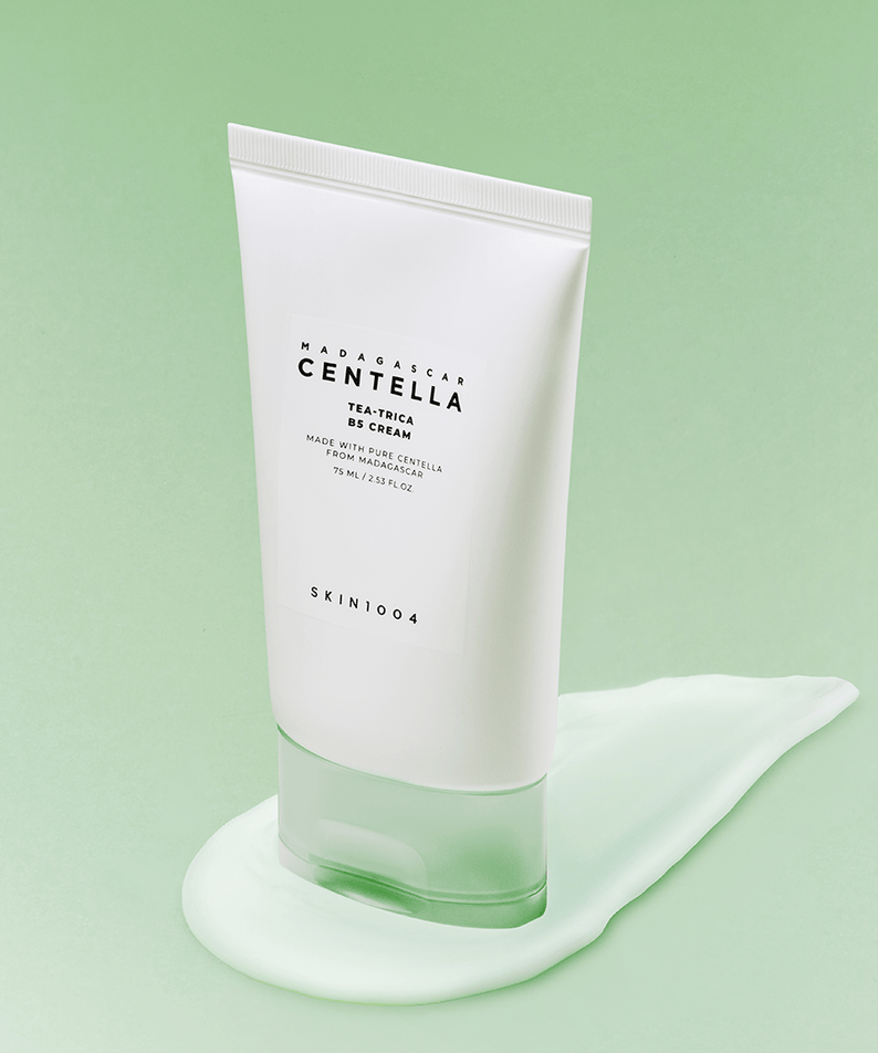 Crème SKIN1004 Madagascar Centella Tea-trica B5 75ml sur fond vert, soin de la peau nourrissant et apaisant, texture crémeuse.